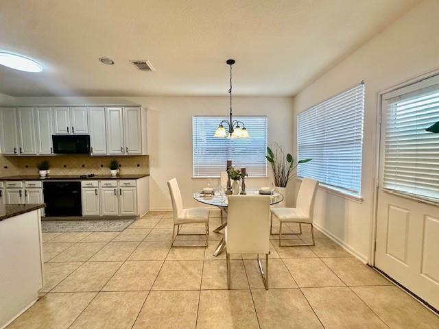 4126 Winesap Bend Dr, Stafford, TX 77477 - dining area featuring a chandelier and light tile patterned floors