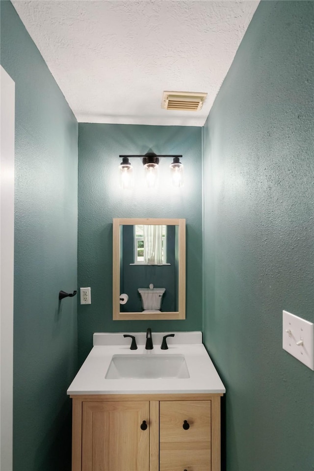 33933 Deer Creek Way, Stagecoach, TX 77355 - bathroom featuring vanity and a textured ceiling