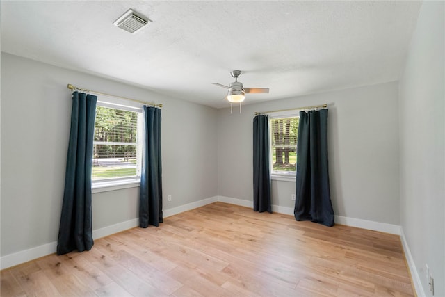 33933 Deer Creek Way, Stagecoach, TX 77355 - unfurnished room with healthy amount of natural light, light wood-style floors, and a ceiling fan