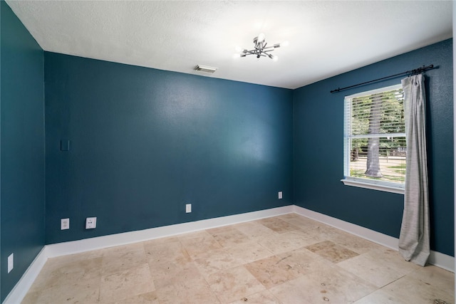 33933 Deer Creek Way, Stagecoach, TX 77355 - spare room featuring a chandelier and a textured ceiling