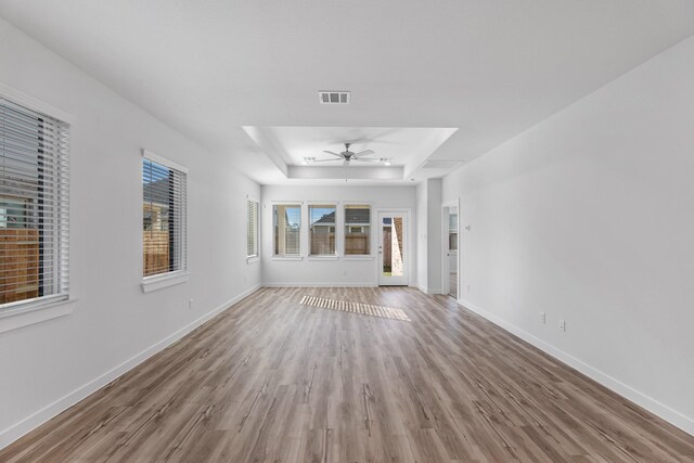 19376 Poppy Village Cir, Magnolia, TX 77355 - unfurnished living room with a raised ceiling, a ceiling fan, and wood finished floors
