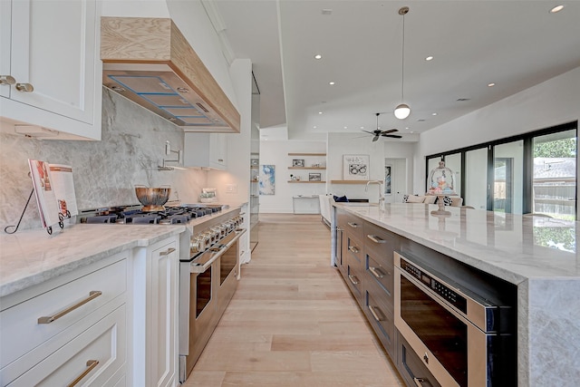1506 W 43rd St, Houston, TX 77018 - kitchen featuring double oven range, premium range hood, white cabinetry, light stone counters, and tasteful backsplash
