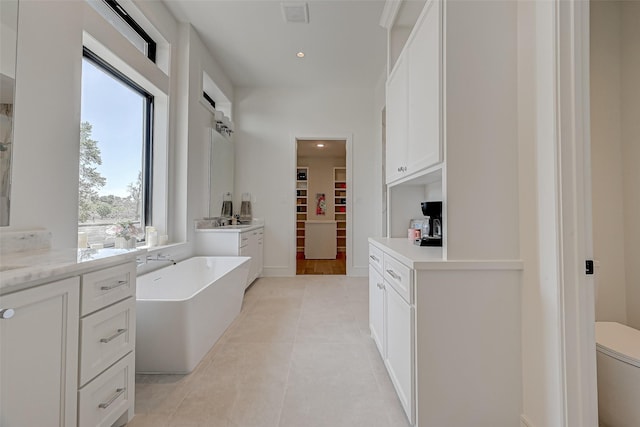 1506 W 43rd St, Houston, TX 77018 - bathroom featuring a freestanding tub, a spacious closet, vanity, tile patterned floors, and recessed lighting