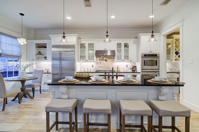 1022 W 22nd St, Houston, TX 77008 - kitchen featuring appliances with stainless steel finishes, under cabinet range hood, backsplash, white cabinets, and crown molding