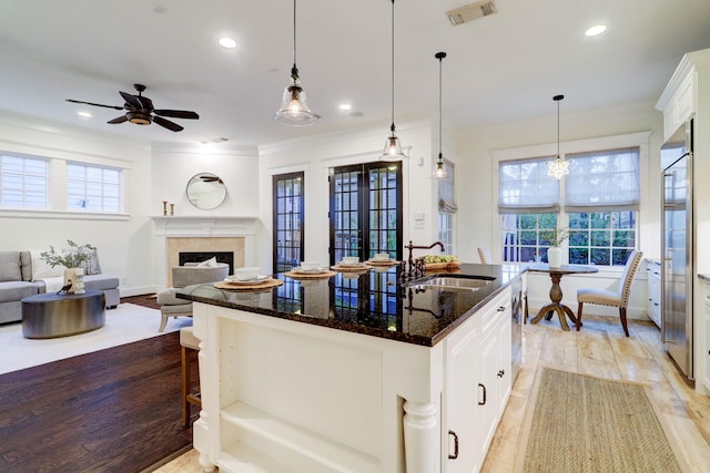 1022 W 22nd St, Houston, TX 77008 - kitchen featuring ceiling fan, dark stone countertops, healthy amount of natural light, white cabinets, and ornamental molding