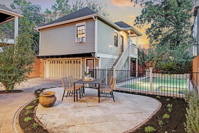 1022 W 22nd St, Houston, TX 77008 - patio terrace at dusk featuring an attached garage, a patio, outdoor dining space, and stairs
