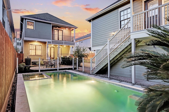 1022 W 22nd St, Houston, TX 77008 - rear view of property featuring stairs, a fenced backyard, a balcony, and a pool with connected hot tub