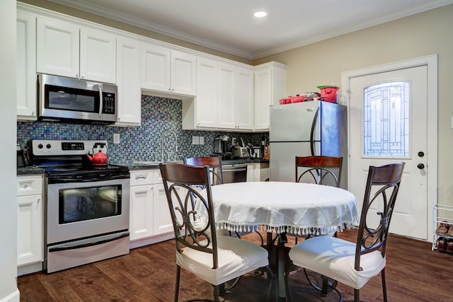 1022 W 22nd St, Houston, TX 77008 - kitchen featuring stainless steel appliances, dark countertops, dark wood finished floors, ornamental molding, and recessed lighting