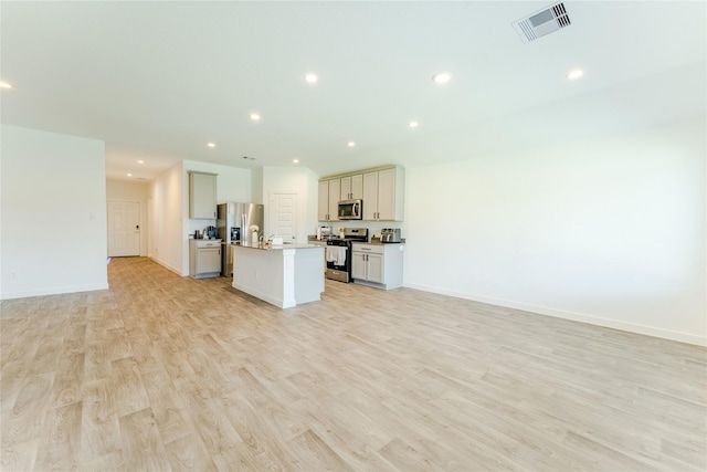 31714 Brandon Mill Trl, Fulshear, TX 77441 - kitchen featuring appliances with stainless steel finishes, open floor plan, a center island with sink, light wood-type flooring, and recessed lighting