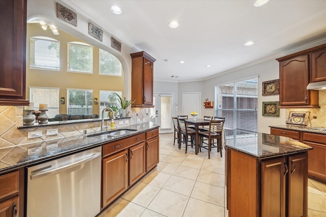 7815 Camden Hollow Ln, Humble, TX 77396 - kitchen with appliances with stainless steel finishes, dark stone counters, tasteful backsplash, ornamental molding, and light tile patterned floors