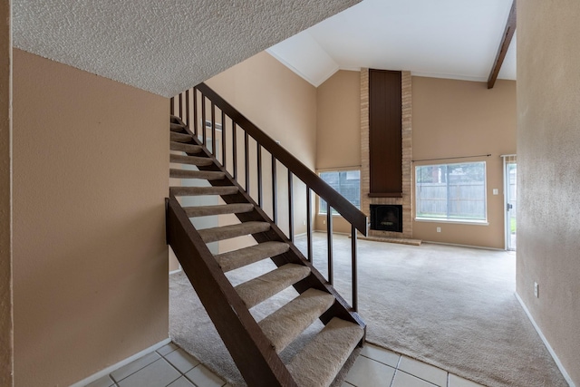 16830 Spruce Run Dr, Spring, TX 77379 - staircase featuring a fireplace, tile patterned floors, carpet floors, high vaulted ceiling, and a textured wall