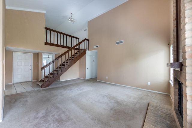16830 Spruce Run Dr, Spring, TX 77379 - unfurnished living room with high vaulted ceiling, stairway, carpet floors, healthy amount of natural light, and a chandelier