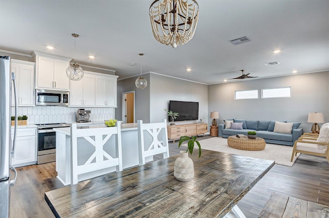 1743 Blue Water Hwy, Surfside Beach, TX 77541 - dining room with light wood-style floors, recessed lighting, crown molding, ceiling fan, and a chandelier
