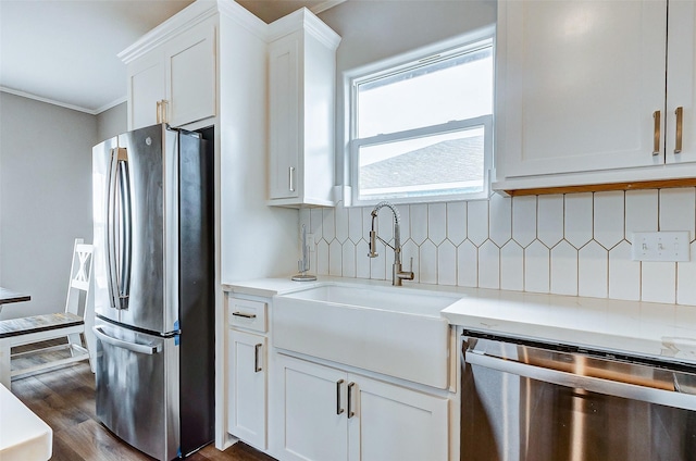 1743 Blue Water Hwy, Surfside Beach, TX 77541 - kitchen featuring stainless steel appliances, ornamental molding, light countertops, white cabinetry, and tasteful backsplash