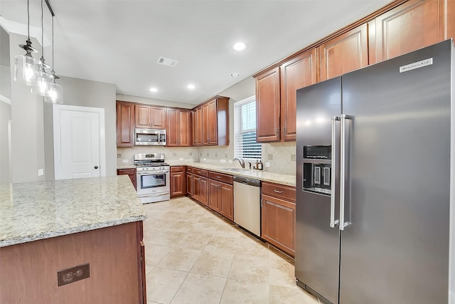 6222 Deer Run Xing, Katy, TX 77493 - kitchen with stainless steel appliances, decorative backsplash, light stone counters, recessed lighting, and brown cabinets
