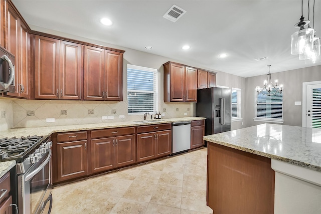 6222 Deer Run Xing, Katy, TX 77493 - kitchen with appliances with stainless steel finishes, a chandelier, backsplash, recessed lighting, and light stone countertops