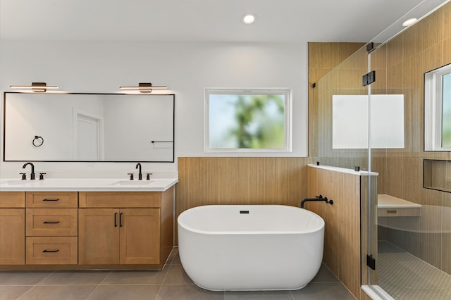 507 Middle St, Houston, TX 77003 - bathroom with a shower stall, a soaking tub, wainscoting, double vanity, and tile patterned flooring