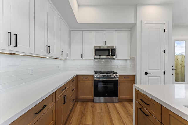 507 Middle St, Houston, TX 77003 - kitchen with stainless steel appliances, light countertops, light wood-style flooring, and decorative backsplash