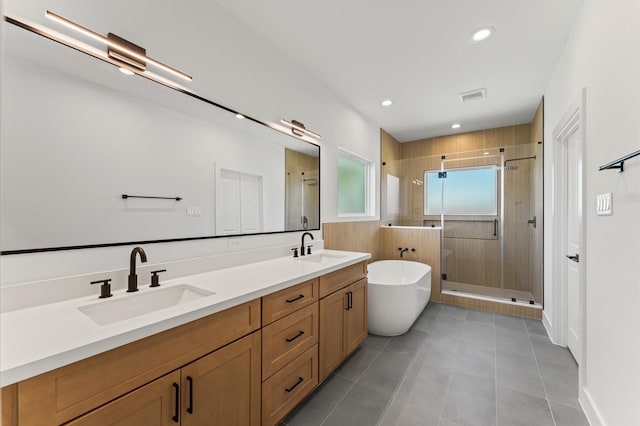 507 Middle St, Houston, TX 77003 - bathroom with a shower stall, a soaking tub, tile patterned flooring, double vanity, and recessed lighting