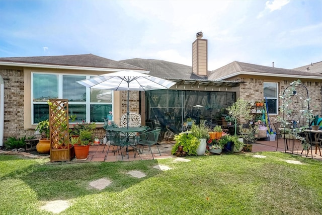 21714 Venture Park Dr, Richmond, TX 77406 - rear view of house with a patio, a lawn, a chimney, and brick siding