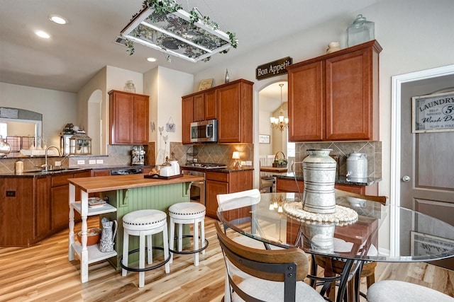 21714 Venture Park Dr, Richmond, TX 77406 - kitchen with stainless steel appliances, arched walkways, a chandelier, wood counters, and backsplash