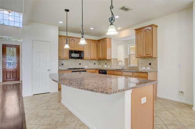 13508 Sweet Wind Ct, Pearland, TX 77584 - kitchen with black microwave, a kitchen island, backsplash, light stone countertops, and recessed lighting