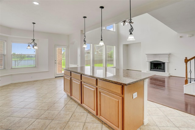 13508 Sweet Wind Ct, Pearland, TX 77584 - kitchen with light tile patterned floors, plenty of natural light, light stone counters, a fireplace with raised hearth, and recessed lighting