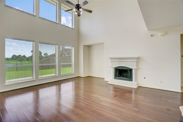 13508 Sweet Wind Ct, Pearland, TX 77584 - unfurnished living room featuring a high ceiling, a ceiling fan, hardwood / wood-style flooring, and a fireplace with raised hearth