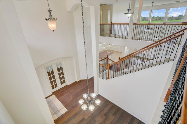 13508 Sweet Wind Ct, Pearland, TX 77584 - stairs with a high ceiling, wood finished floors, a chandelier, and french doors
