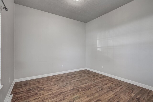 8014 Pine Wood Ct, Baytown, TX 77523 - empty room featuring dark wood-style flooring and a textured ceiling