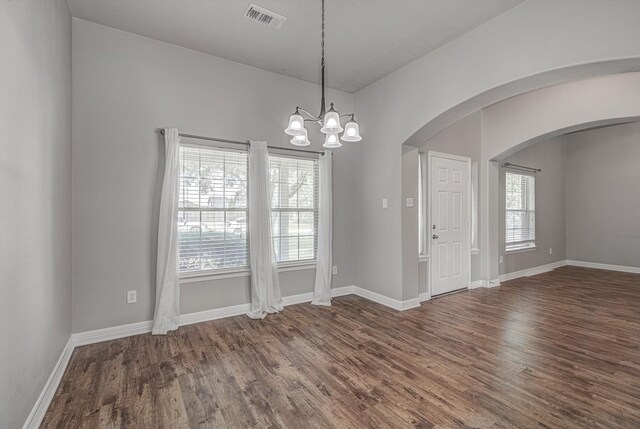 8014 Pine Wood Ct, Baytown, TX 77523 - unfurnished room with wood finished floors, arched walkways, and a chandelier