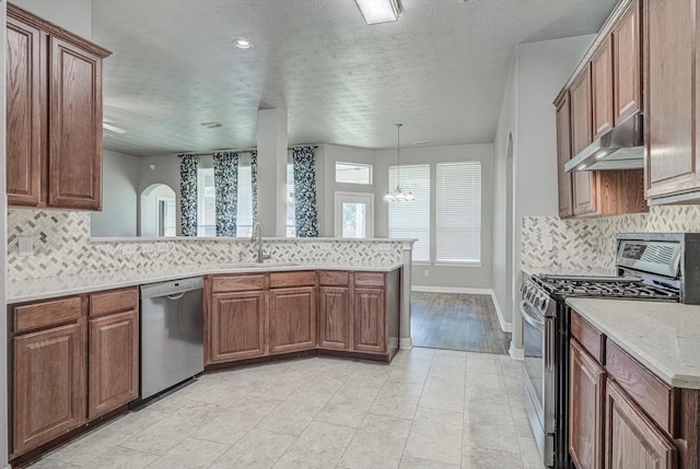 8014 Pine Wood Ct, Baytown, TX 77523 - kitchen featuring stainless steel appliances, under cabinet range hood, a peninsula, a textured ceiling, and backsplash