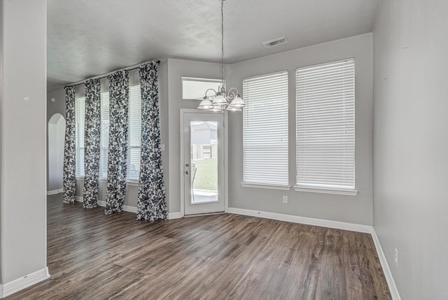 8014 Pine Wood Ct, Baytown, TX 77523 - unfurnished dining area featuring a chandelier, wood finished floors, and arched walkways