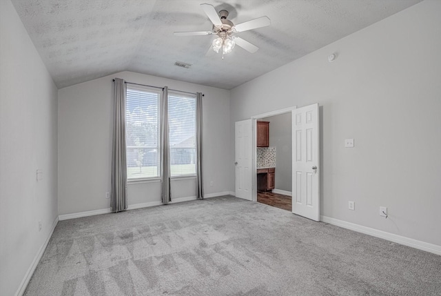 8014 Pine Wood Ct, Baytown, TX 77523 - unfurnished bedroom with light colored carpet, lofted ceiling, a textured ceiling, ceiling fan, and ensuite bathroom