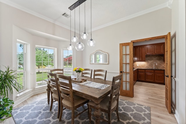 9119 Bush Buck Ln, Conroe, TX 77303 - dining room featuring light wood-style flooring and crown molding