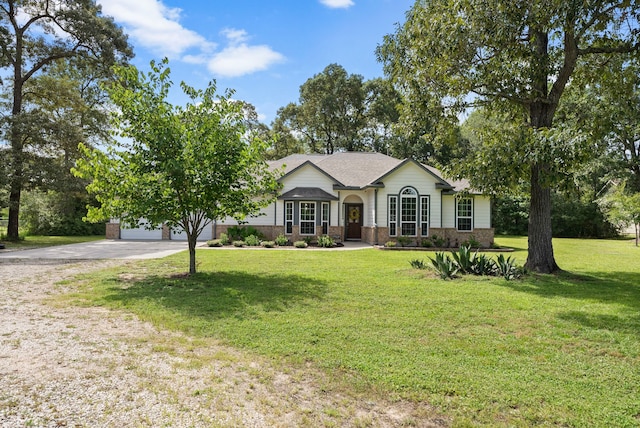 9119 Bush Buck Ln, Conroe, TX 77303 - ranch-style home featuring brick siding, a front lawn, and driveway