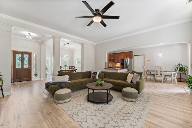 9119 Bush Buck Ln, Conroe, TX 77303 - living room with decorative columns, light wood-style flooring, crown molding, and a ceiling fan
