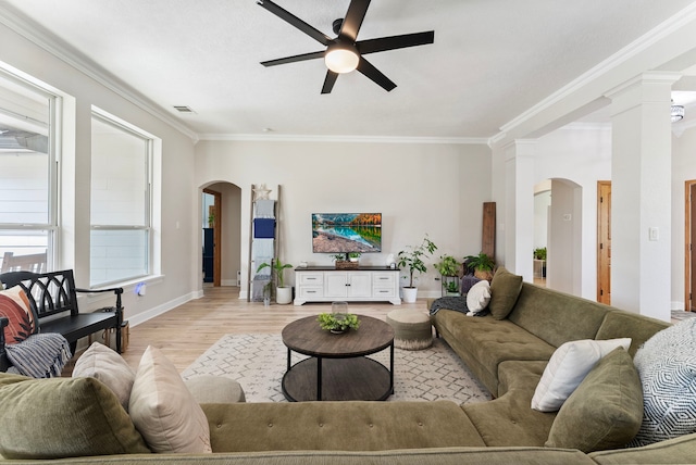 9119 Bush Buck Ln, Conroe, TX 77303 - living room featuring arched walkways, a ceiling fan, ornamental molding, light wood finished floors, and decorative columns