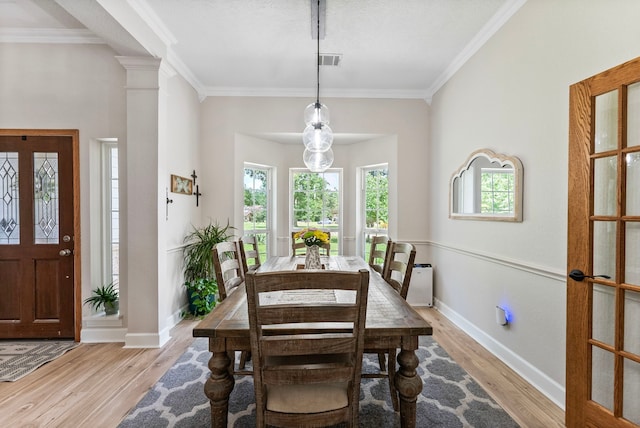 9119 Bush Buck Ln, Conroe, TX 77303 - dining room with wood finished floors, crown molding, and decorative columns