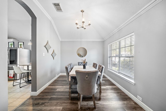 1727 Caldbeck Ln, Fresno, TX 77545 - dining space with vaulted ceiling, arched walkways, a chandelier, ornamental molding, and wood finished floors