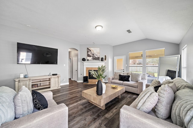 1727 Caldbeck Ln, Fresno, TX 77545 - living room with arched walkways, dark wood-style flooring, lofted ceiling, and a tile fireplace