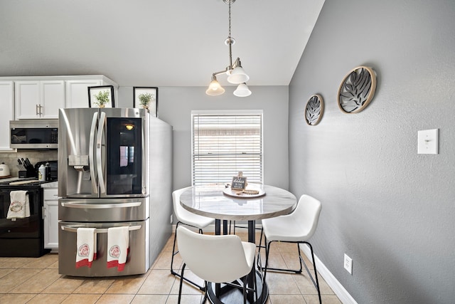 1727 Caldbeck Ln, Fresno, TX 77545 - kitchen with appliances with stainless steel finishes, light tile patterned flooring, white cabinetry, a textured wall, and vaulted ceiling