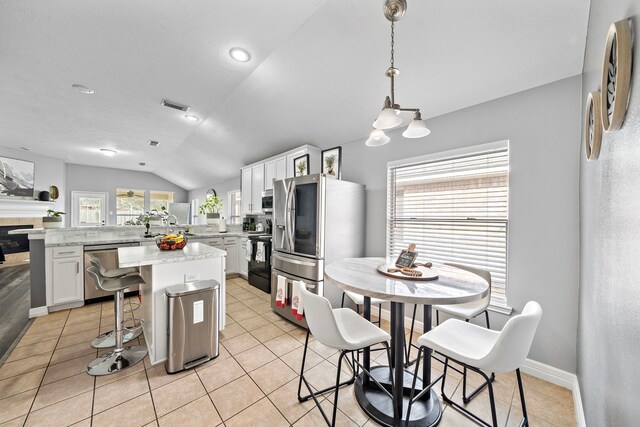 1727 Caldbeck Ln, Fresno, TX 77545 - kitchen featuring appliances with stainless steel finishes, vaulted ceiling, white cabinetry, and healthy amount of natural light