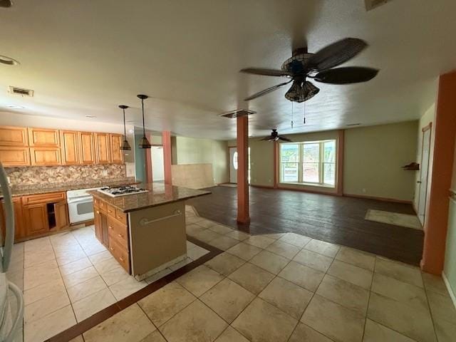804 Tovrea Rd, Alvin, TX 77511 - kitchen featuring ornate columns, white appliances, a ceiling fan, light tile patterned floors, and a center island