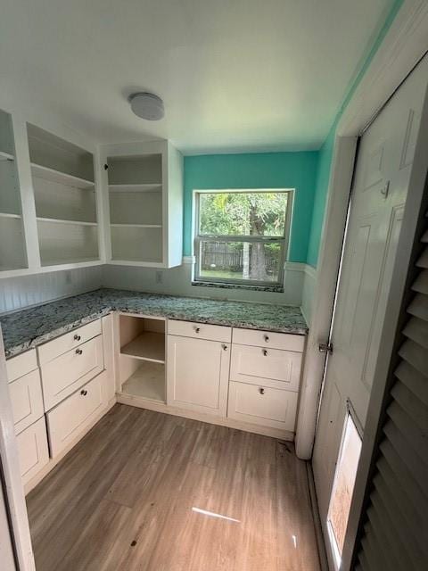 804 Tovrea Rd, Alvin, TX 77511 - kitchen with open shelves, wood finished floors, and light stone counters
