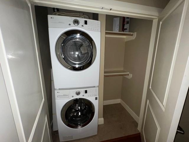 300 St Joseph Pkwy Unit 116, Houston, TX 77002 - laundry area with stacked washer / dryer and tile patterned floors