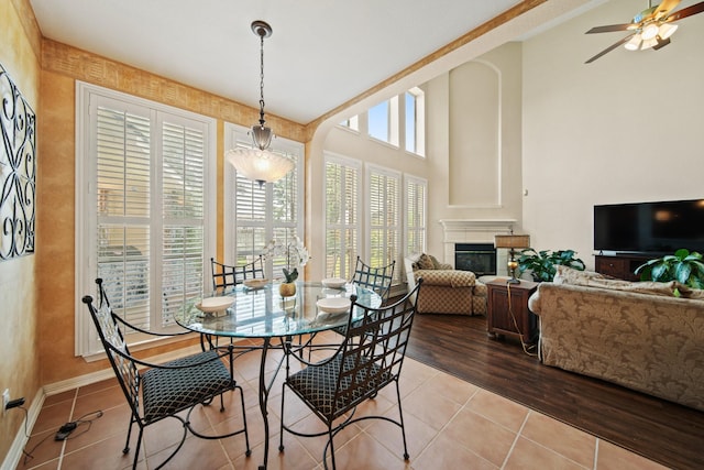 3207 Summerwind Ct, Pearland, TX 77584 - dining room with a glass covered fireplace, ceiling fan, light tile patterned flooring, and high vaulted ceiling