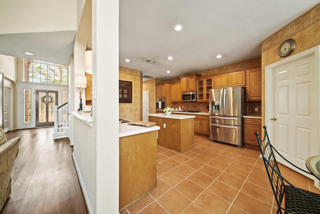 3207 Summerwind Ct, Pearland, TX 77584 - kitchen with stainless steel appliances, recessed lighting, a center island, light countertops, and brown cabinetry