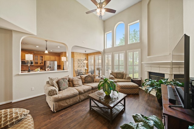 3207 Summerwind Ct, Pearland, TX 77584 - living area with arched walkways, a high ceiling, ceiling fan, hardwood / wood-style floors, and a glass covered fireplace