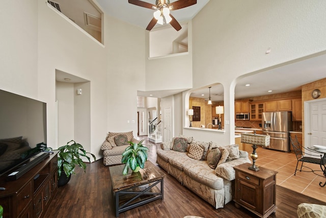 3207 Summerwind Ct, Pearland, TX 77584 - living area with ceiling fan, a high ceiling, arched walkways, and wood finished floors